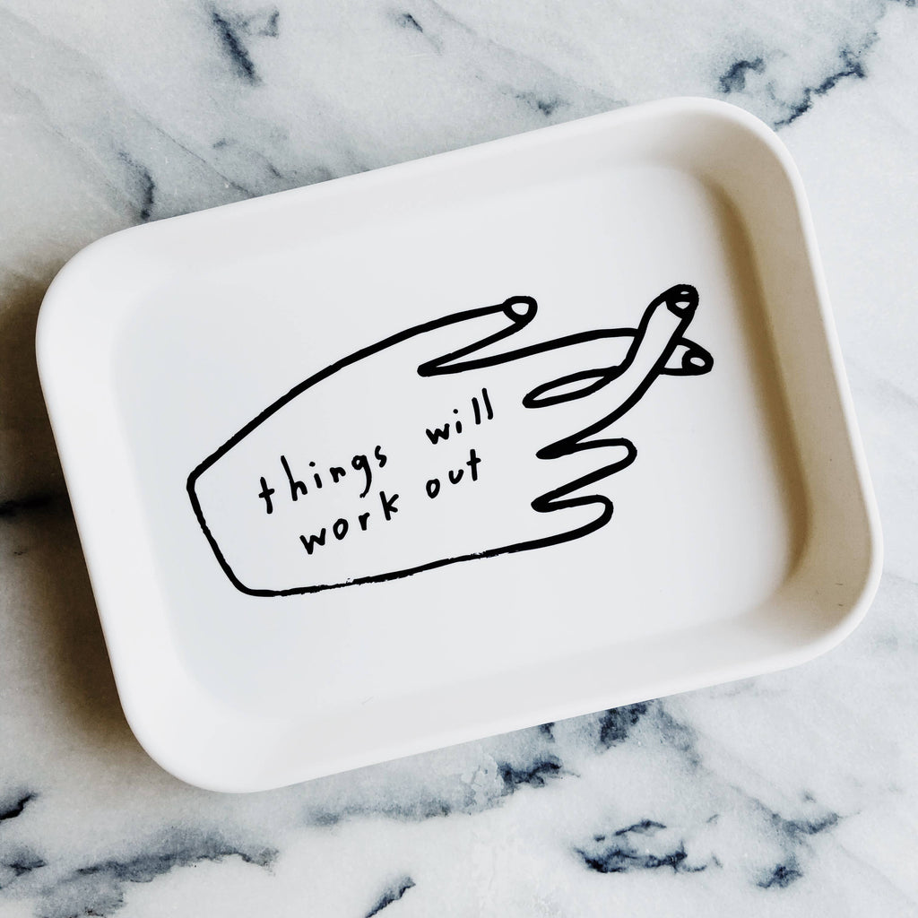 White tray with a black hand-drawn illustration and text 'things will work out' on a marble surface
