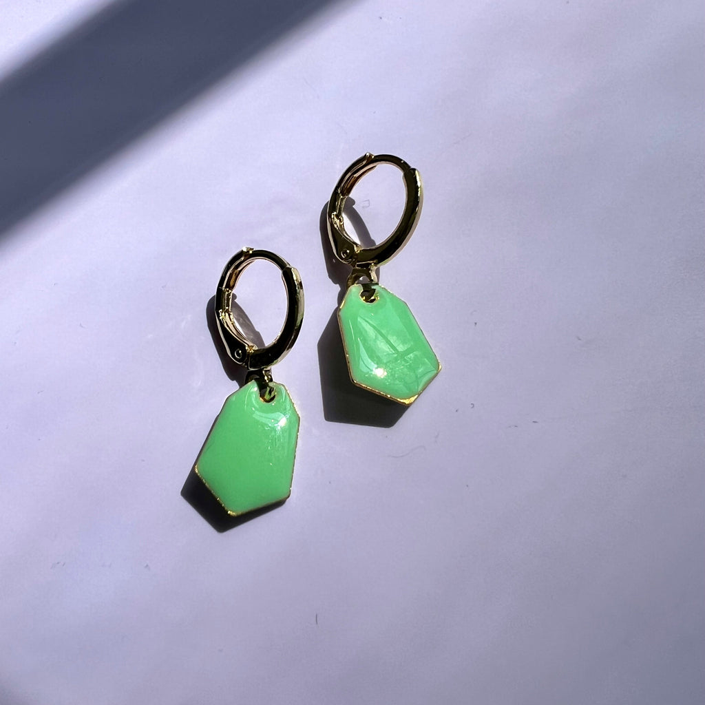 Green earrings on a light gray background
