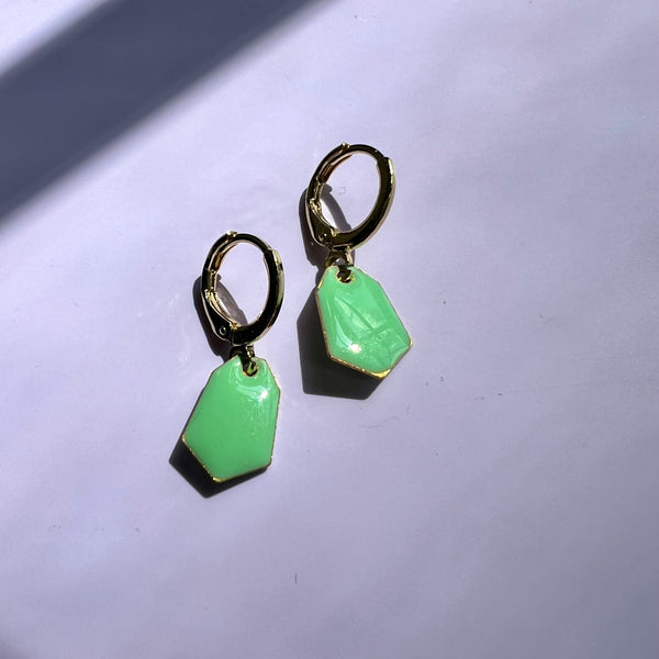 Green earrings on a light gray background