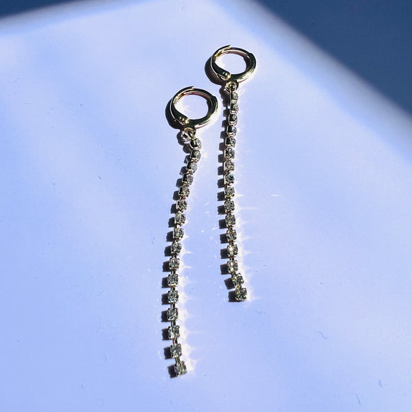 Pair of silver chain earrings on a light blue background