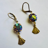 Pair of gold earrings with colorful gemstones on a white background
