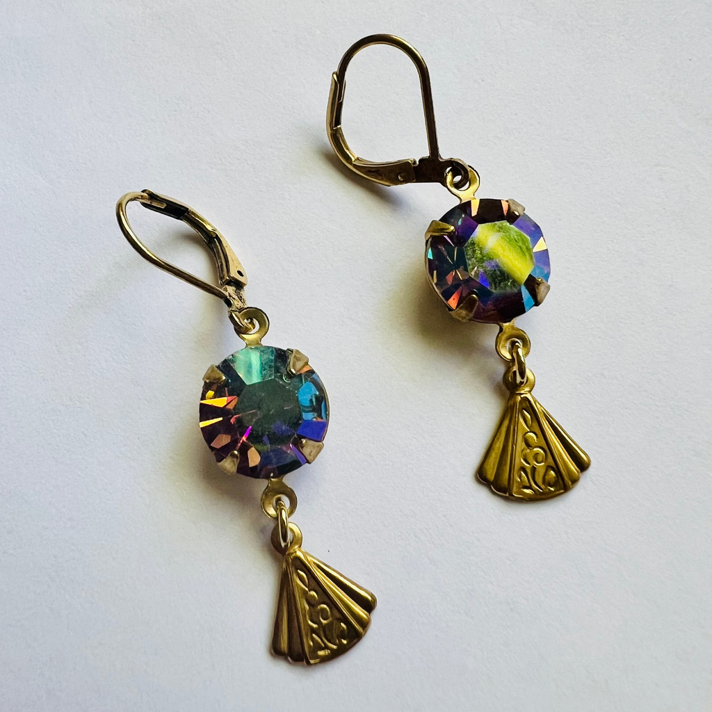 Pair of gold earrings with colorful gemstones on a white background