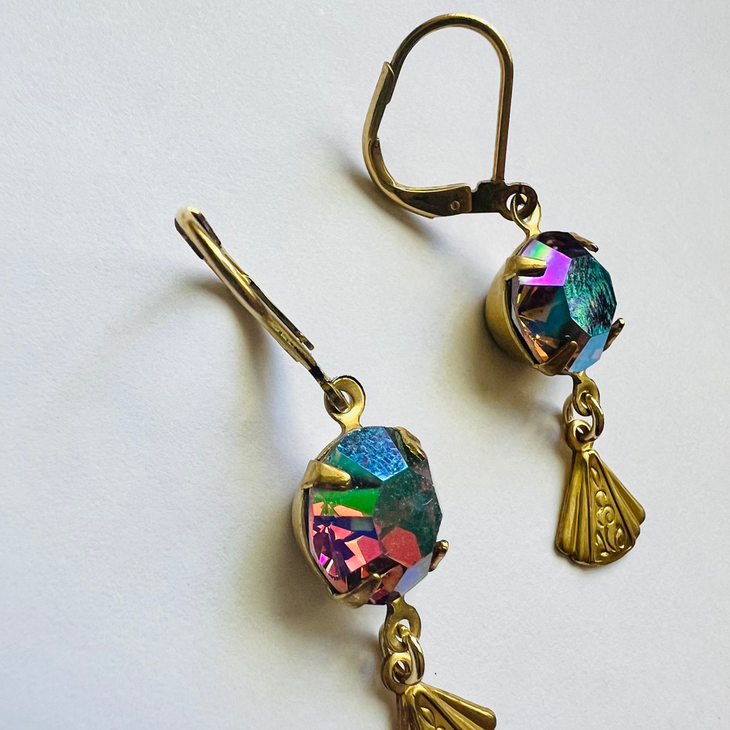 Pair of earrings with colorful gemstones and gold accents on a white background