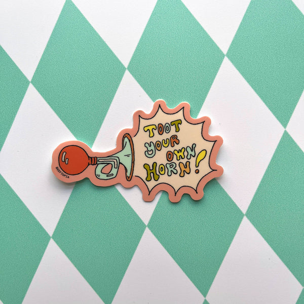 Vinyl sticker with 'Toot Your Own Horn!' text on a green and white checkered background