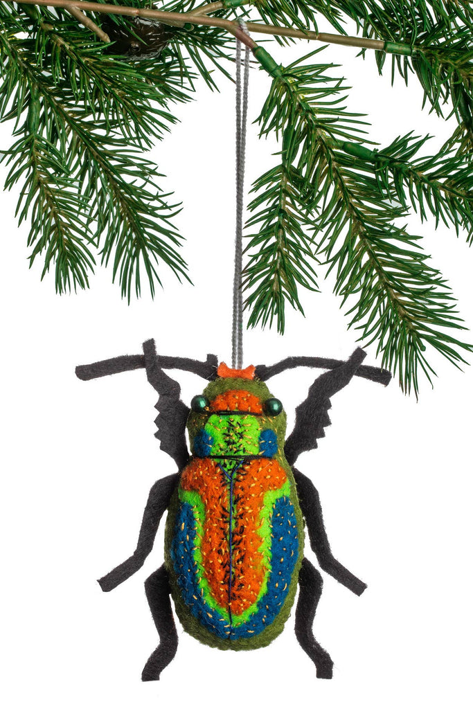 Colorful beetle ornament hanging on a Christmas tree branch
