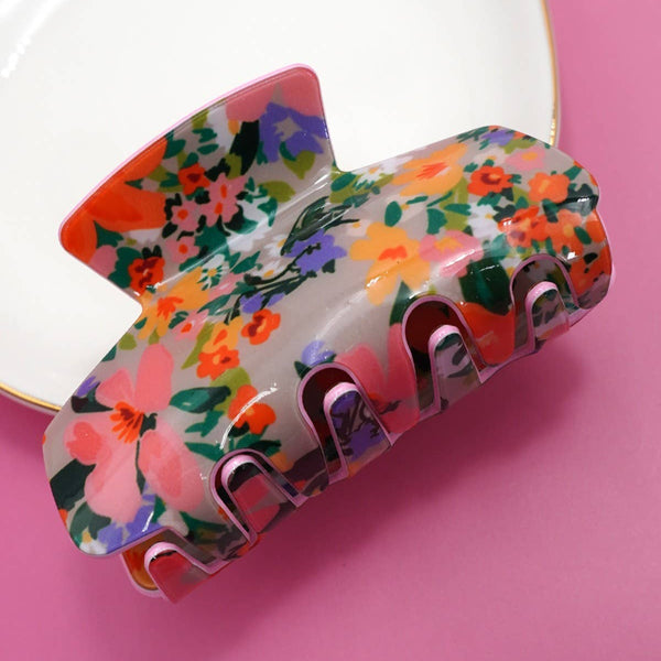 Floral-patterned hair clip on a pink background