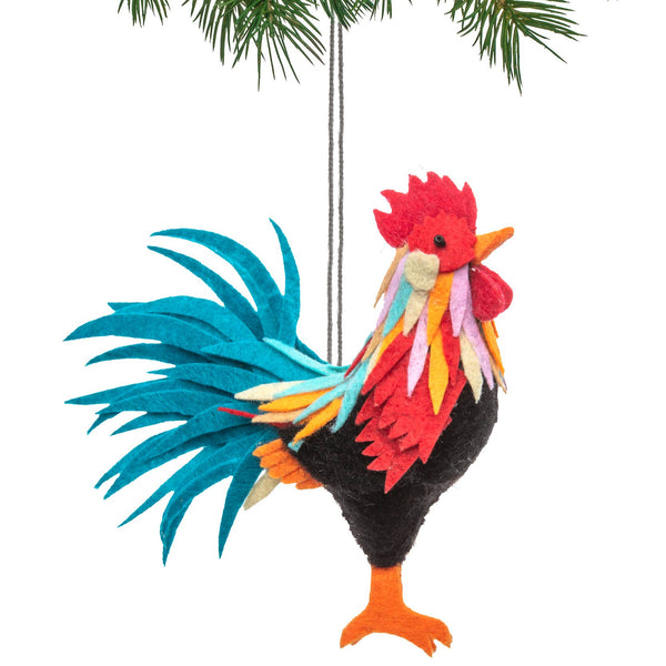 Colorful rooster ornament hanging from a branch on a white background