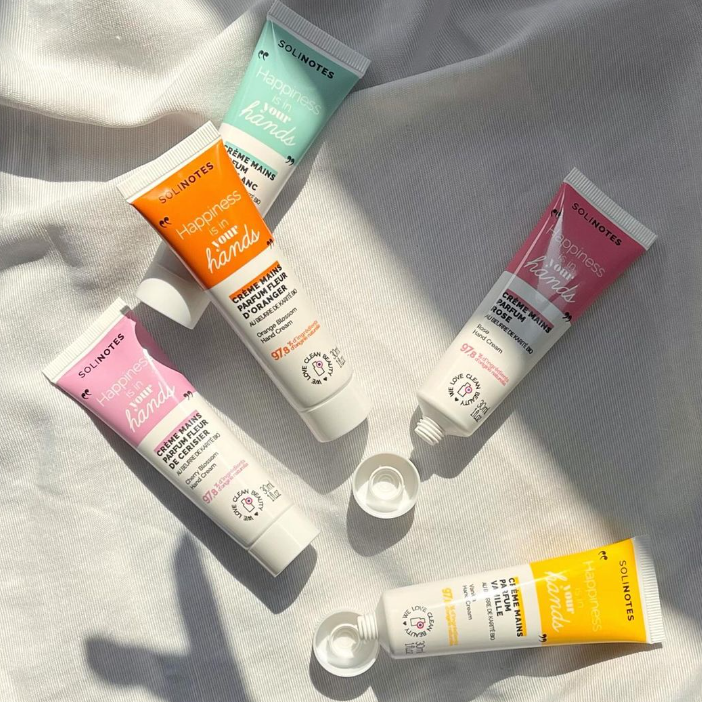 Five tubes of hand cream on a light fabric background